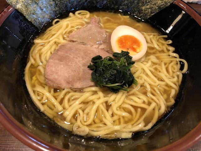やや濁った茶色のスープに太麺とチャーシューとほうれん草と海苔と煮卵が載った家系ラーメン